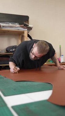 Beyaz sakallı adam bir atölyede bronzlaştırıcı olarak çalışıyor.