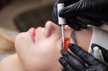 Beyaz kadın kirpik temizleme prosedüründen geçiyor.