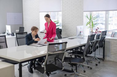 Beyaz kadın astlarına talimat veriyor.