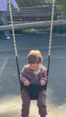 Küçük beyaz çocuk sallanıyor salıncakta