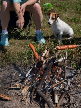 Kafkasyalı çift ateşte sosis kızartıyor.