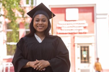 Mezuniyet elbisesi içinde mutlu bir Afrikalı kadın.