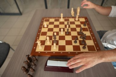 Orta yaşlı beyaz bir adamın satranç oynaması yakındır.