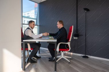 İki beyaz adam bir iş toplantısında iletişim kuruyor.