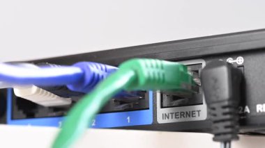 Bir kadın internet portundan yönlendiriciyle kablo çekiyor.