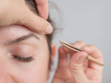 Beyaz kadın kaş düzeltme prosedüründen geçiyor.