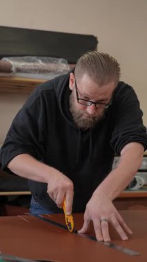 Beyaz sakallı adam bir atölyede bronzlaştırıcı olarak çalışıyor.