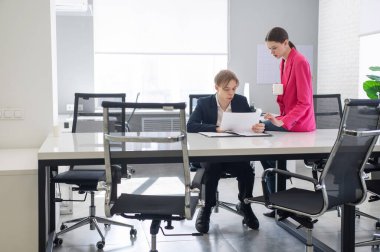 Beyaz kadın astlarına talimat veriyor.