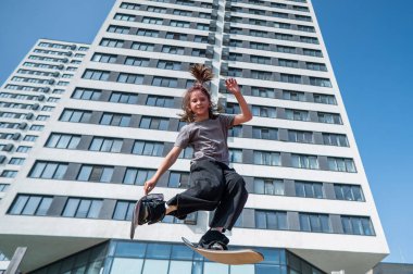 Kız trambolinde kayak numarası yapıyor.