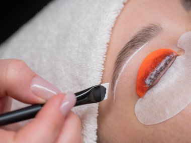 Beyaz kadın kirpik temizleme prosedüründen geçiyor.