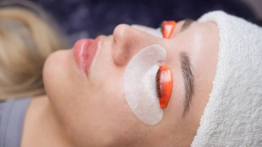 Beyaz kadın kirpik temizleme prosedüründen geçiyor.