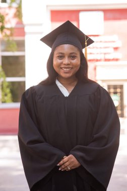 Mezuniyet elbisesi içinde mutlu bir Afrikalı kadın.