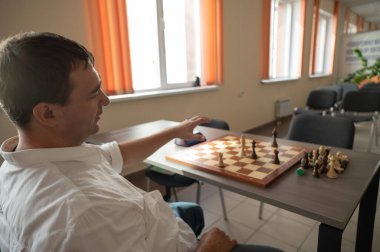 Orta yaşlı beyaz adam satranç oynuyor.