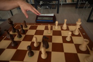 Bir adam satranç saatini değiştirir.