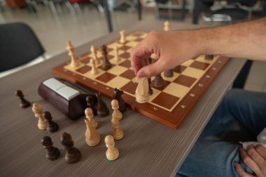 Orta yaşlı beyaz bir adamın satranç oynaması yakındır.