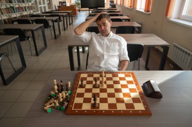 Orta yaşlı beyaz adam satranç oynuyor.