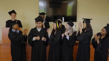 Asyalı genç adam mezun olduğu için sınıf arkadaşları tarafından tebrik edildi.