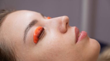 Beyaz kadın kirpik temizleme prosedüründen geçiyor.