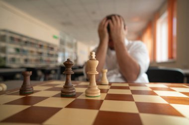 Orta yaşlı beyaz adam satranç oynuyor.