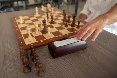 Orta yaşlı beyaz bir adamın satranç oynaması yakındır.