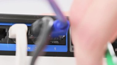 Bir kadın internet portundan yönlendiriciyle kablo çekiyor.
