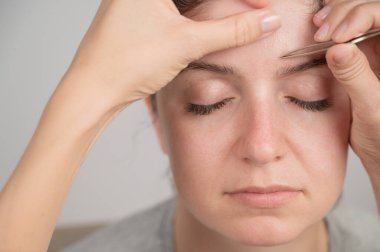 Beyaz kadın kaş düzeltme prosedüründen geçiyor.