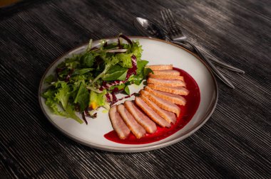 Kızarmış ördek bir tabakta parçalara ayrılmış.