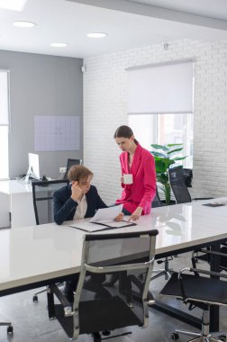 Beyaz kadın astlarına talimat veriyor.