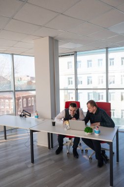 İki beyaz adam bir masada oturup iş tartışıyorlar.