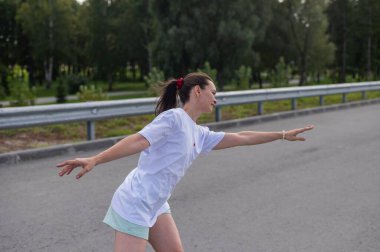 Beyaz şortlu kadın paten kayıyor.