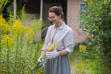 Genç beyaz kadın çalıları buduyor.