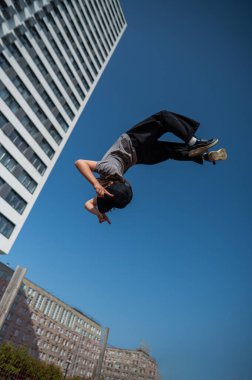 Bir kız trambolinde jimnastik yapıyor.