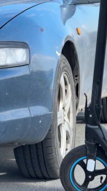 Beyaz bir kadın motosiklet sürerken arabaya çarpıyor.