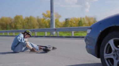Araba çarptıktan sonra scooter süren beyaz bir kadın.