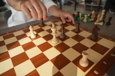 Orta yaşlı beyaz bir adamın satranç oynaması yakındır.