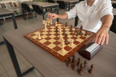 Orta yaşlı beyaz bir adamın satranç oynaması yakındır.