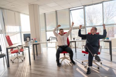 İki beyaz adam iş yerinde eğleniyor.