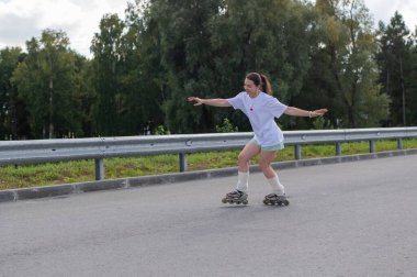 Beyaz şortlu kadın paten kayıyor.