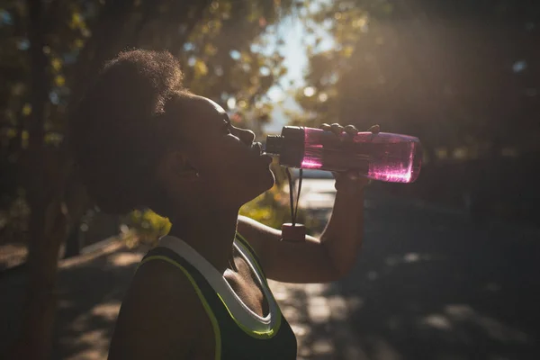 アフリカ系アメリカ人女性は日当たりの良い通りで屋外で飲料水を行使する 健康的なアウトドアライフスタイルフィットネストレーニング — ストック写真
