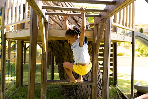 非洲裔美国女孩在操场上玩耍时悬挂在木制的猴栏上 享乐和周末概念 — 图库照片