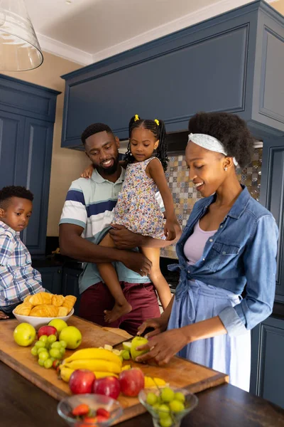 幸せなアフリカ系アメリカ人の子供と夫は キッチンカウンターで果物を切る女性を見ています コピースペース 変更されていない 一緒に 子供時代 新鮮な ライフスタイルと家庭の概念 — ストック写真