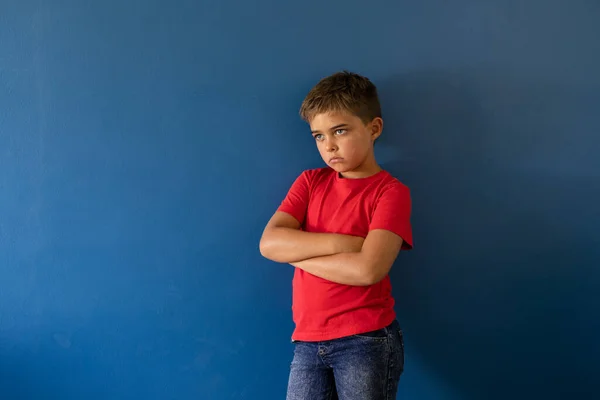 Kavkazský Zamyšlený Chlapec Zkříženýma Rukama Dívá Stranou Zatímco Stojí Modrém — Stock fotografie