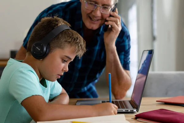Avô Caucasiano Falando Por Telefone Olhando Para Neto Escrevendo Lição — Fotografia de Stock