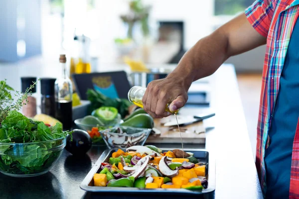 Félidős Férfi Vacsorát Készít Olajat Önt Apróra Vágott Zöldségekre Konyhában — Stock Fotó