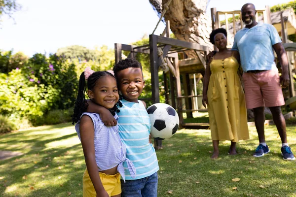 サッカーボールと祖父母が公園に立っているアフリカ系アメリカ人のかわいい兄弟 変更されていない 一緒に 子供時代 スポーツ 引退した 楽しさと週末のコンセプト — ストック写真