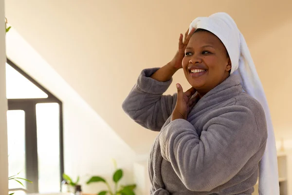 Счастливая Афроамериканка Халате Смотрящая Себя Зеркало Ванной Самообслуживание Здоровье Красота — стоковое фото