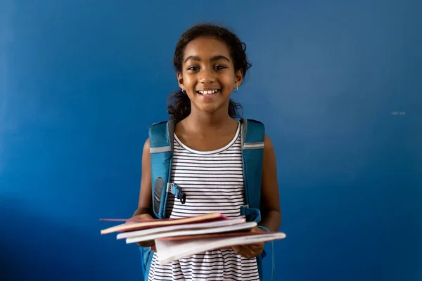 Retrato Colegiala Biracial Feliz Sosteniendo Cuadernos Sonriendo Sobre Fondo Azul —  Fotos de Stock