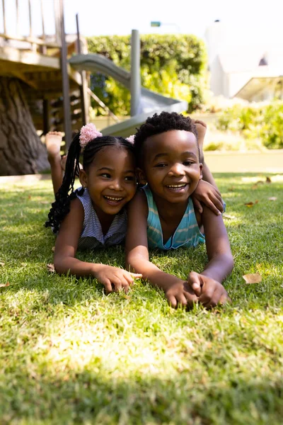 可爱的非洲裔美国兄弟姐妹躺在公园草地上的画像 不变的 家庭的 团聚的 童年的 微笑的 快乐的 放松的和周末的观念 — 图库照片
