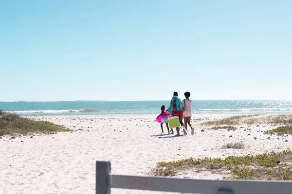 アフリカ系アメリカ人の両親と子供たちは澄んだ空の下で美しい海に向かってビーチを歩いています コピースペース 変更されていない 一緒に 子供時代 楽しさと夏のコンセプト — ストック写真