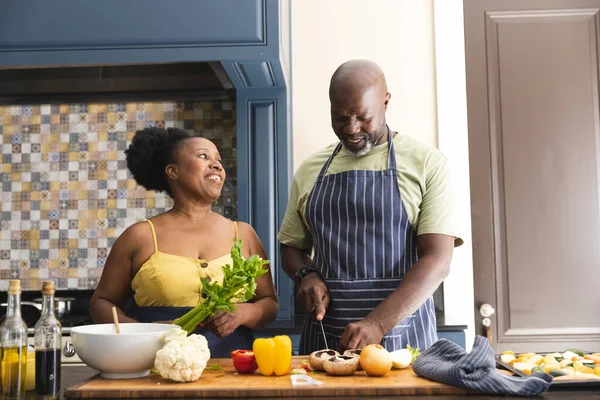 Ευτυχισμένο Ζευγάρι Αφροαμερικανών Που Φοράνε Ποδιές Και Μαγειρεύουν Στην Κουζίνα — Φωτογραφία Αρχείου